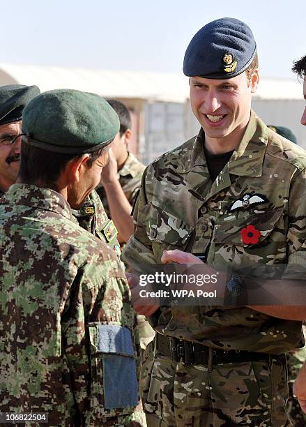 Prince William talks to a member of the Afghan Army, before a Remembrance Day ceremony at Camp Bastion on November 14, 2010 in Afghanistan....