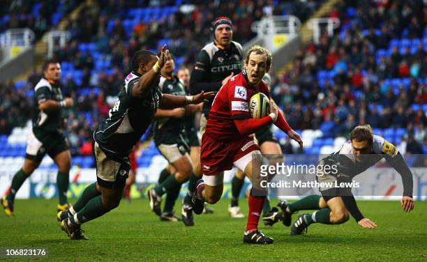Lee Wiliams of the Scarlets breaks through the defence of Steffon Armitage of London Irish to score a try during the LV Anglo Welsh Cup match between...