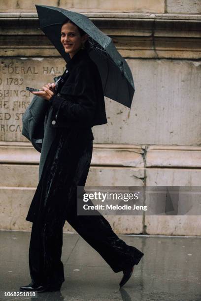 Model Aymeline Valade carries an umbrella and J.W. Anderson jacket in the rain after the Proenza Schouler show during New York Fashion Week...