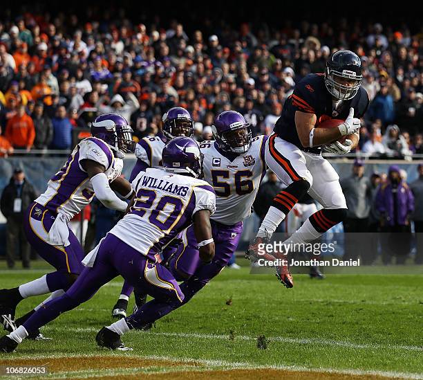 Greg Olsen of the Chicago Bears catches a touchdown pass over E.J. Henderson and Madieu Williams of the Minnesota Vikings at Soldier Field on...