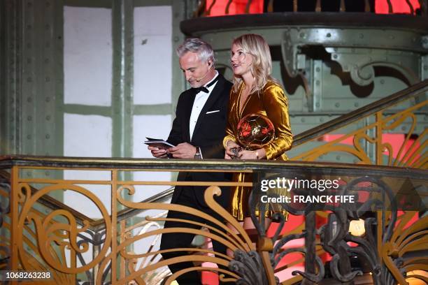 Olympique Lyonnais' Norwegian forward Ada Hegerberg walks with former French footballer and host David Ginola after receiving the women's 2018...