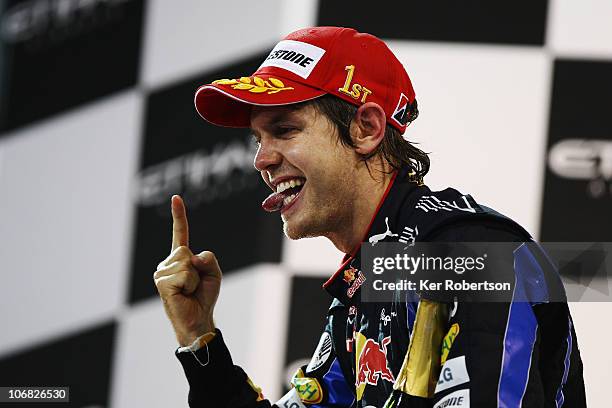 Race winner and F1 2010 World Champion Sebastian Vettel of Germany and Red Bull Racing celebrates on the podium following the Abu Dhabi Formula One...