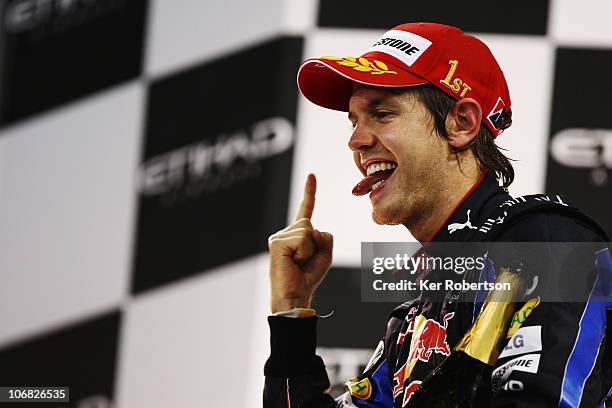 Race winner and F1 2010 World Champion Sebastian Vettel of Germany and Red Bull Racing celebrates on the podium following the Abu Dhabi Formula One...