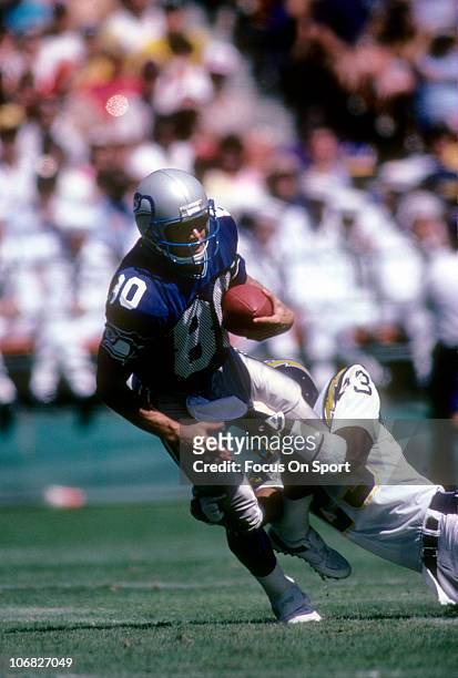 Wide Receiver Steve Largent of the Seattle Seahawks is tackled from behind by defensive back Danny Walters of the San Diego Chargers during an NFL...