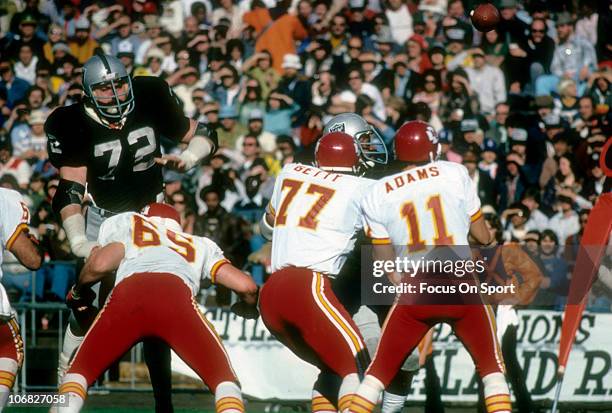 John Matuszak of the Oakland Raiders is blocked by Tom Condon of the Kansas City Chiefs during an NFL football game at the Oakland-Alameda County...