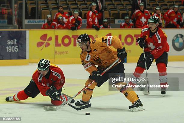 Patrick Reimer of Germany race for the puck against John Gobbi of Switzerland during the German Ice Hockey Cup 2010 third round game between Germany...