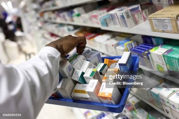 Pharmacist collects packets of boxed medication from the shelves of a pharmacy in London, U.K., on Monday, Dec. 14, 2015. U.K. Prime Minister Theresa...