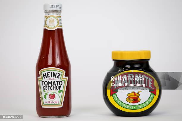 Bottle of tomato ketchup, manufactured by Kraft Heinz Co., left, stands next to a jar of Marmite, manufactured by Unilever NV, in this arranged...