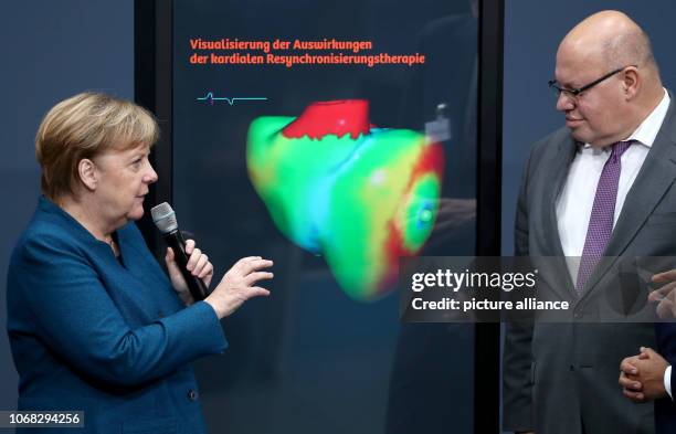 December 2018, Bavaria, Nürnberg: Federal Chancellor Angela Merkel and Peter Altmaier , Federal Minister of Economics and Energy, look at a "digital...