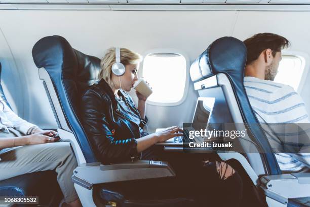 kvinnliga passagerare använder laptop under flygning - woman airplane headphones bildbanksfoton och bilder