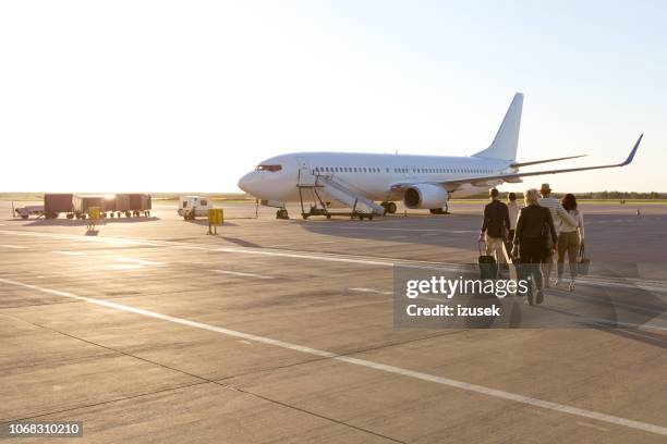 passengers boarding a flight - couple airplane stock pictures, royalty-free photos & images