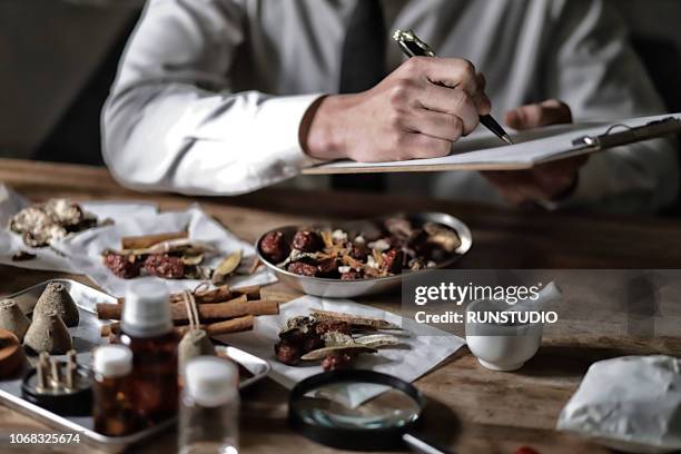 oriental medical doctor checking various dried herbal medicine - same person different looks stock-fotos und bilder