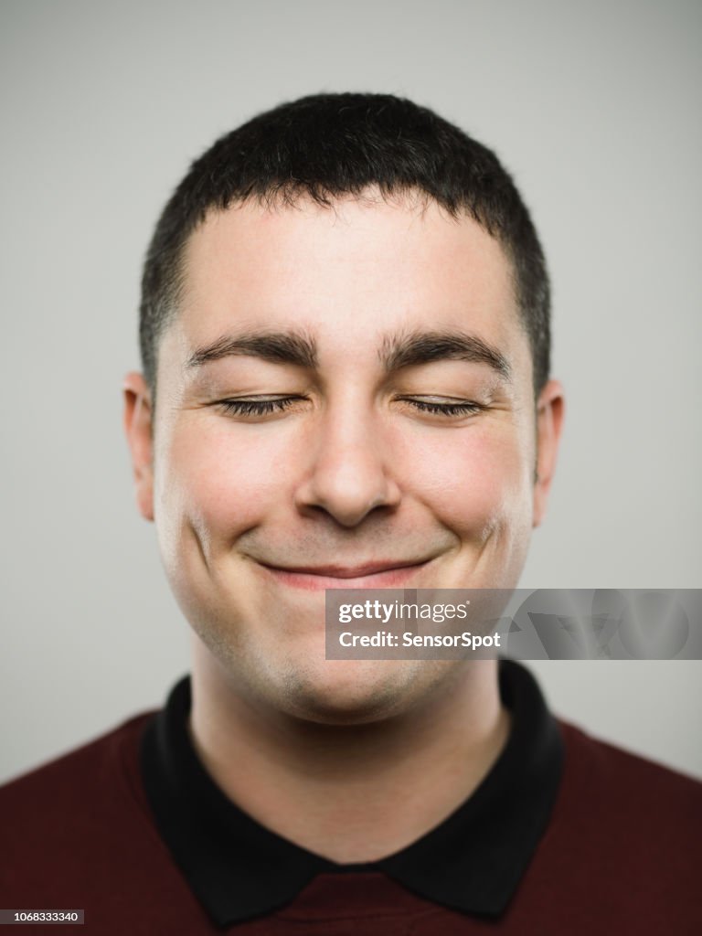 Portrait of a young caucassian man closing eyes and smiling