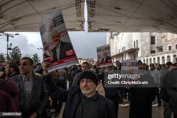 Man holds a poster showing a picture of Jamal Khashoggi after taking part in an absence prayer held after Friday pray at Fatih Mosque on November 16,...