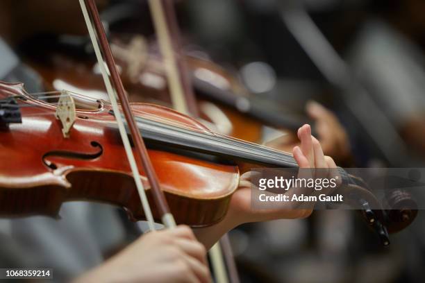 young people playing violins - strijkstok stockfoto's en -beelden