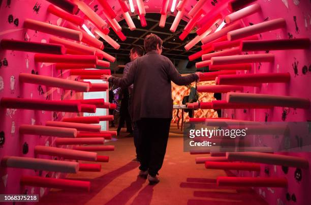 Woman walks through a tunnel as she visits the exhibition entitled "Microbiote" at the "Cite des sciences et de l'industrie" science museum, in...
