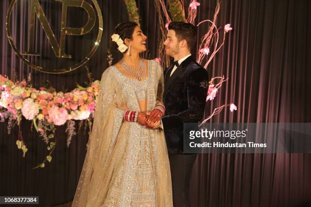 Newly-wed Bollywood actor Priyanka Chopra and American singer Nick Jonas pose for photos during their wedding reception, at Taj Palace on December 4,...