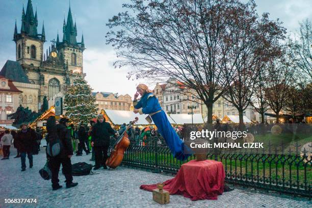 Street performer dressed in Aladdin costume performs near the Christmas market with the illuminated Christmas tree at the Old Town Square on December...