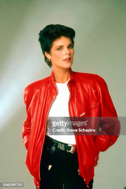 Portrait of American actress Ali MacGraw as she poses with her hands in the pockets of her red leather jacket, Los Angeles, California, 1982.