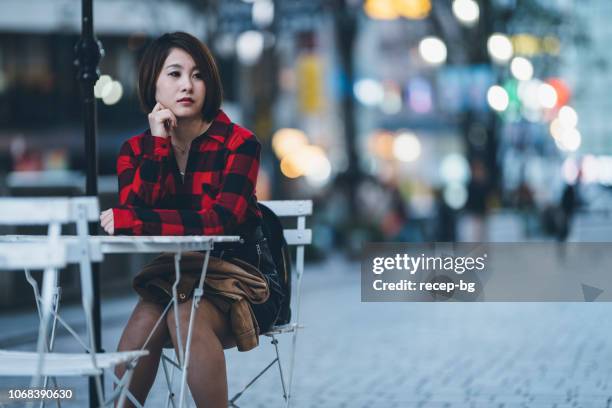 portrait of young woman at night - outdoor cafe blur stock pictures, royalty-free photos & images