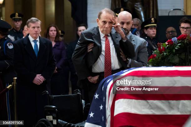 Former Senator Bob Dole stands up and salutes the casket of the late former President George H.W. Bush as he lies in state at the U.S. Capitol,...