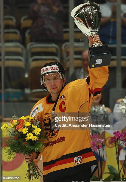 Michael Wolf of Germany celebrates with the winners trophy after the German Ice Hockey Cup 2010 third round game between Germany and Switzerland at...