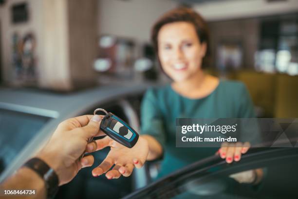 man in de autosleutels geven van nieuwe auto tot zijn vrouw - car keys hand stockfoto's en -beelden