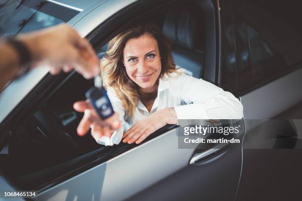 happy woman taking the car keys of the new car - customer test drive stock pictures, royalty-free photos & images