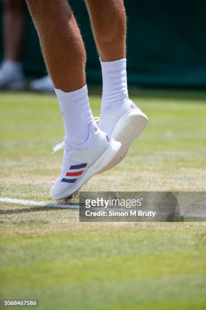 The feet and legs of a serving Lucas Pouille of France during the Wimbledon Lawn Tennis Championship at the All England Lawn Tennis and Croquet Club...
