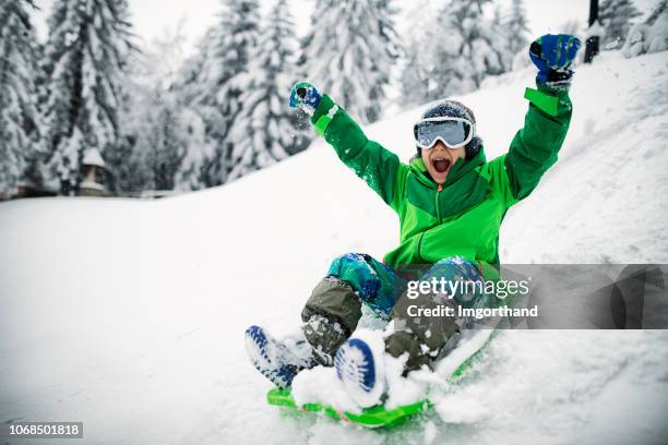 little boy sledding y gritando - sledge fotografías e imágenes de stock