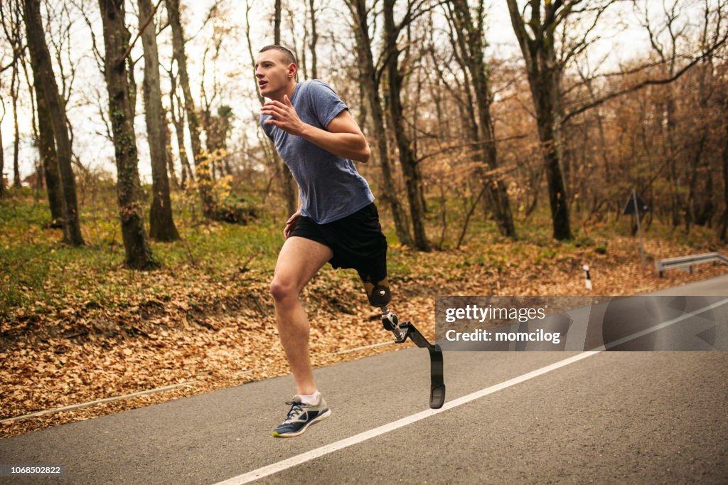 Jonge mannen met prothetische benen lopen in het bos