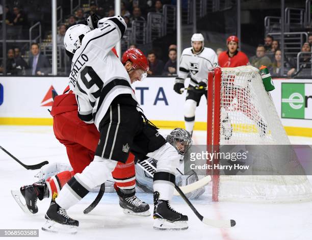 Jonathan Quick of the Los Angeles Kings makes a save in front of Jordan Staal of the Carolina Hurricanes and Alex Iafallo during the first period at...