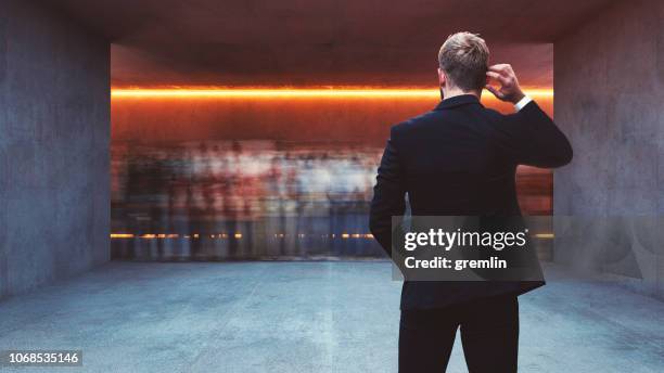 businessman standing in underground corridor - scratching head stock pictures, royalty-free photos & images