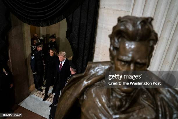 President Donald J. Trump and first lady Melania Trump walk by a statue of former President Andrew Jackson as they arrive to pay their respects to...