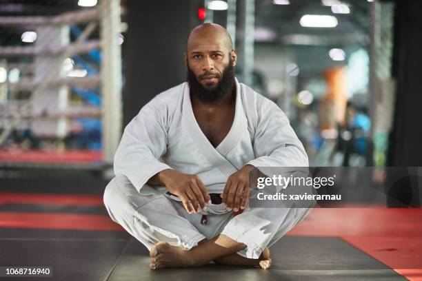 portrait of mixed martial artist sitting at gym - karate stock pictures, royalty-free photos & images