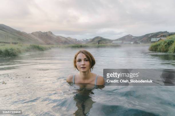 vrouw, rust in hete natuurlijke zwembad in ijsland - bathing in sunset stockfoto's en -beelden