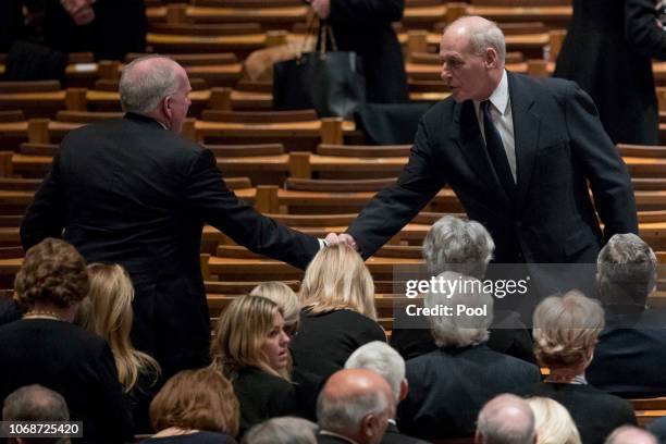 Former CIA Director John Brennan, left, shakes hands with President Donald Trump's Chief of Staff John Kelly, right, before a State Funeral for...