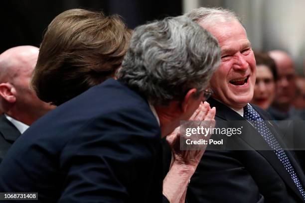 Former President George W. Bush shares a moment with his brother Jeb Bush after speaking at the state funeral for their father, former President...