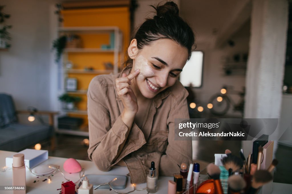 Young woman applying daily cream