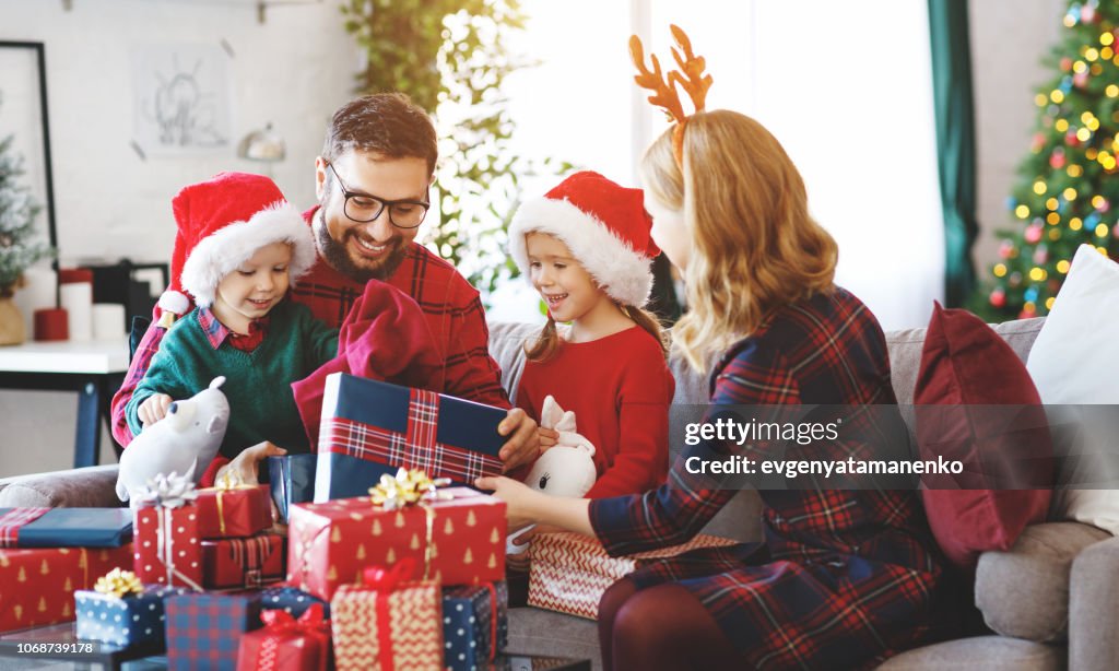 Happy family   open presents on Christmas morning