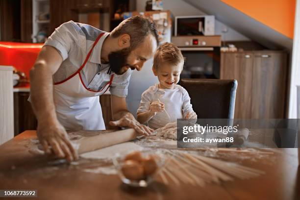 cute little baker and his father making a bread - baking bread stock pictures, royalty-free photos & images