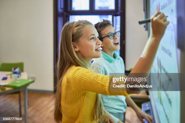 amigos de la escuela trabajan juntos en un proyecto - niño de primaria fotografías e imágenes de stock