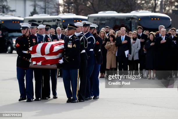 Former President George W. Bush, former first lady Laura Bush and other family members watch as the flag-draped casket of former President George...