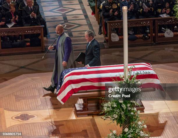 Former President George W. Bush touches the casket of his father afterv providing a eulogy at the state funeral service for his father, former...