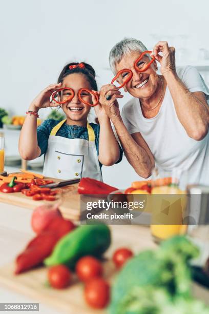 oma en kleindochter spelen met groenten - funny vegetable stockfoto's en -beelden