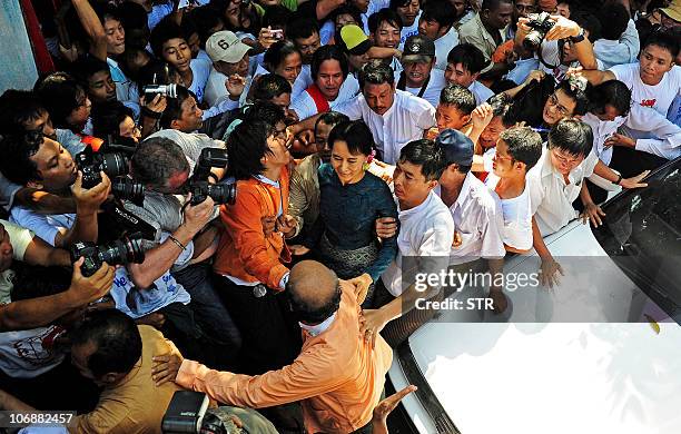 Myanmar's newly-released opposition leader Aung San Suu Kyi is surrounded by supporters and photographers as she arrives at her National League for...