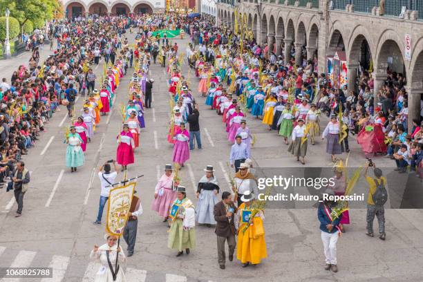 people wearing multicolored dresses and hats marching during the celebration of the palm sunday of easter at ayacucho city, peru. - holy week banner stock pictures, royalty-free photos & images