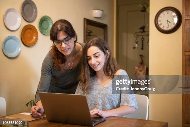 madre che aiuta la figlia adolescente con i compiti sul laptop - girl looking at computer foto e immagini stock