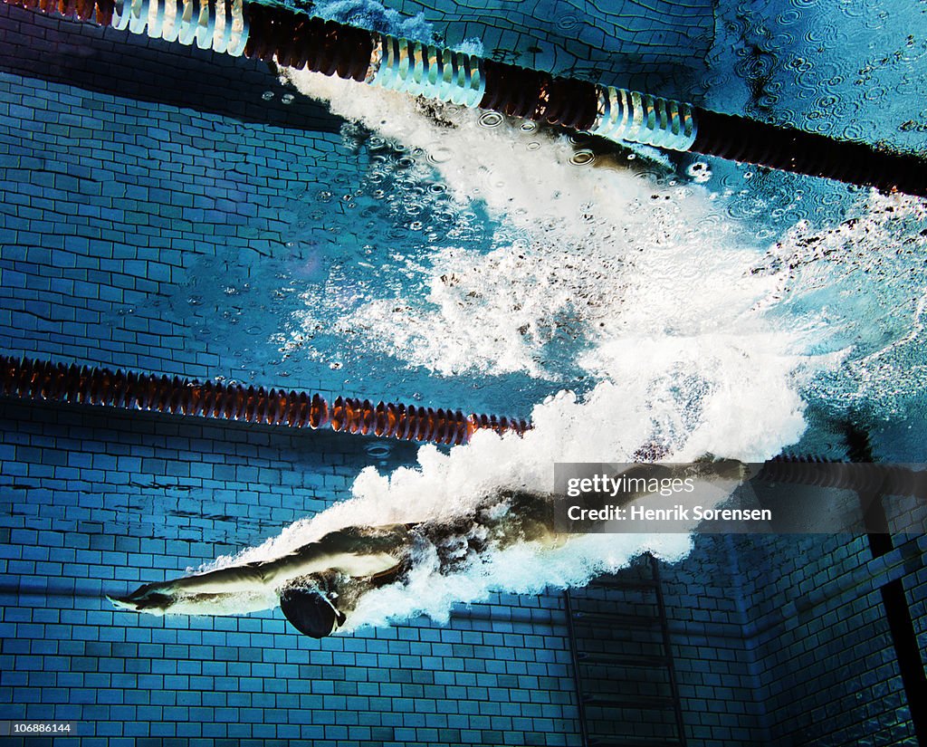 Female swimmer diving into pool