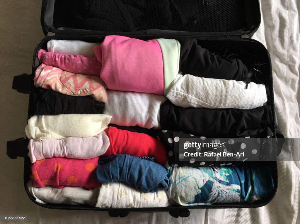 Woman Traveller Open Suitcase on a Bed